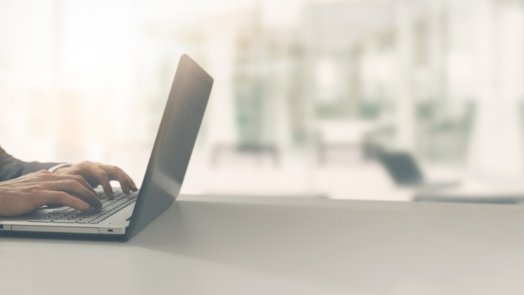 pastor at his desk with laptop preparing a Christmas sermon