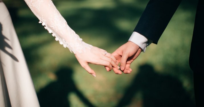 closeup of couple holding hands at a wedding. Blog header for What Does It Mean to Be Unequally Yoked with Unbelievers