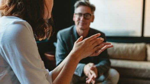 man and woman on coaches talk about a cultural issue