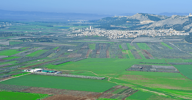modern-day Jezreel Valley, with homes, green fields, and mountains in view
