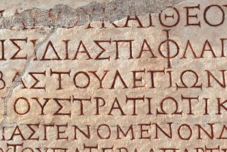 old manuscript page full of biblical greek alphabet