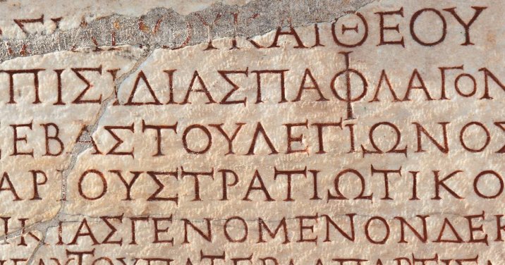 old manuscript page full of biblical greek alphabet