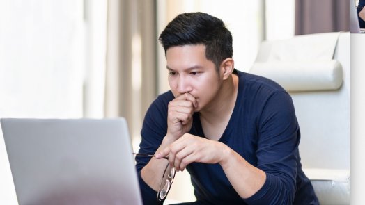 Man reading on a computer for a post about theological journals