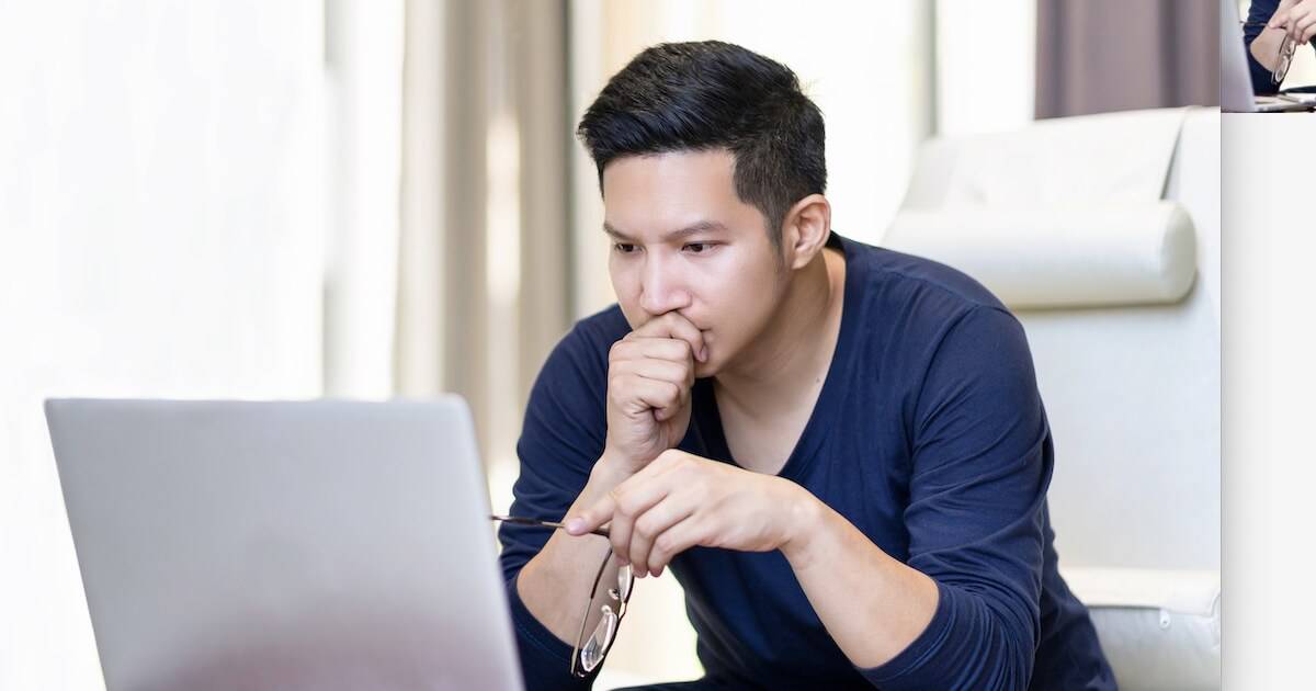 Man reading on a computer for a post about theological journals