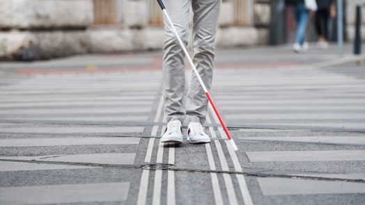 blind person walking across the street