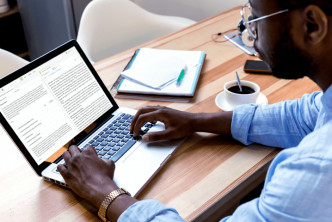 man at desk with open laptop looking at Bible concordances in Logos Bible Software