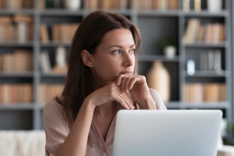 Woman thinking at computer for a post about proverbs