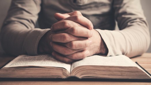 image of man praying over bible for post about old testament prayers