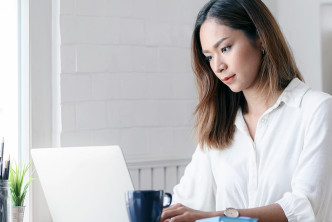 woman at desk uses Logos Bible Software on laptop