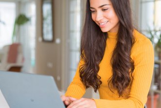 woman at desk uses Logos Bible Software on laptop