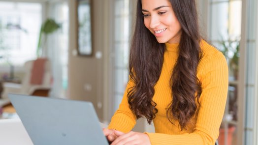 woman at desk uses Logos Bible Software on laptop