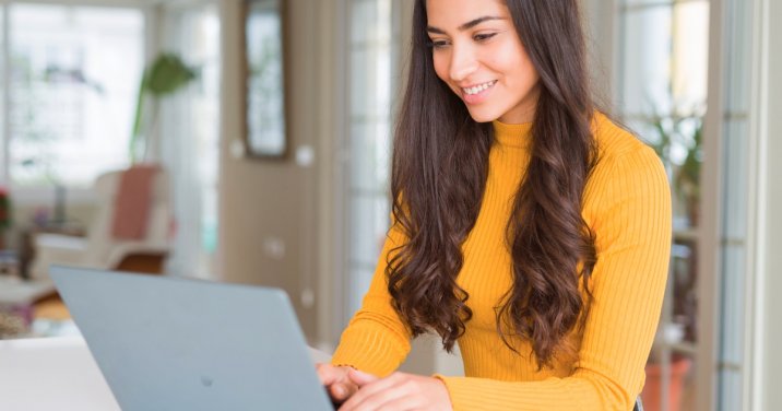 woman at desk uses Logos Bible Software on laptop