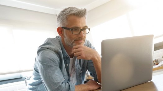 Image of a man on a computer for a post exploring the question what is systematic theology