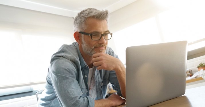 Image of a man on a computer for a post exploring the question what is systematic theology