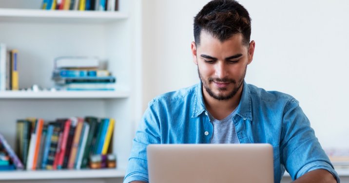 man at desk uses Logos Bible Software on laptop