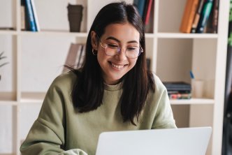 woman at desk studies the Bible on laptop to increase biblical literacy