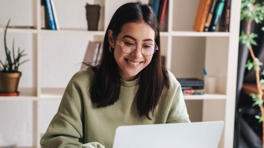 woman at desk studies the Bible on laptop to increase biblical literacy