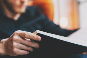 image of man reading a book post about reading goals
