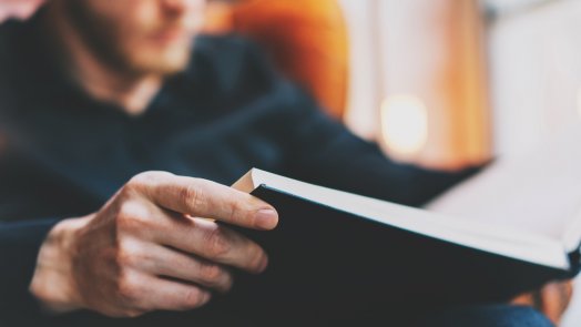 image of man reading a book post about reading goals