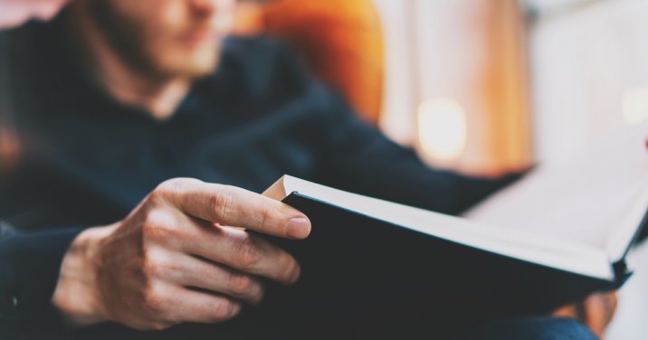 image of man reading a book post about reading goals