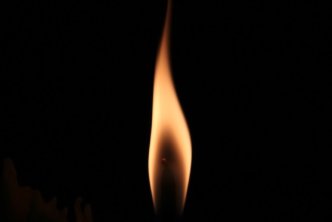 flame flickers against black background to illustrate Pentecost