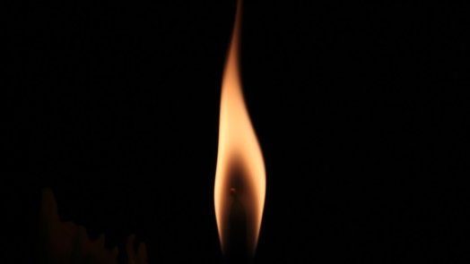 flame flickers against black background to illustrate Pentecost