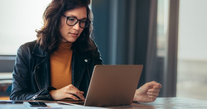woman at desk uses Logos Bible Software on laptop