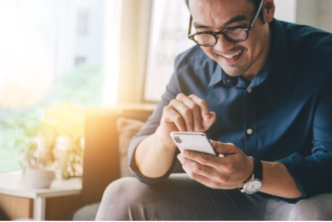 man on couch studies the Bible on his phone with a free Bible app