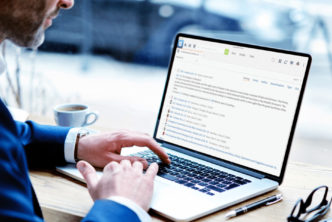 man at desk uses Logos Bible Software on laptop