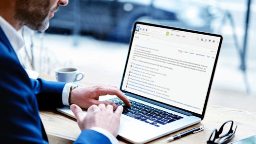 man at desk uses Logos Bible Software on laptop