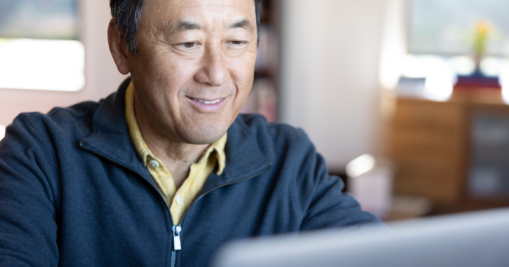 man at desk looks at Logos libraries on laptop