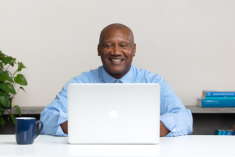 man at desk follows along with Bible study challenge on laptop