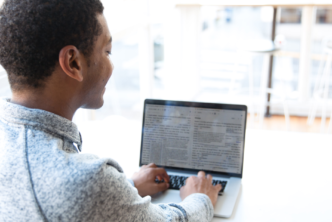 man at desk studies church history on laptop using Logos