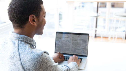 man at desk studies church history on laptop using Logos