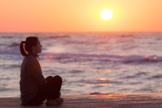woman on beach at sunset contemplates grace